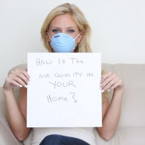 Woman in hospital mask holding an air quality sign
